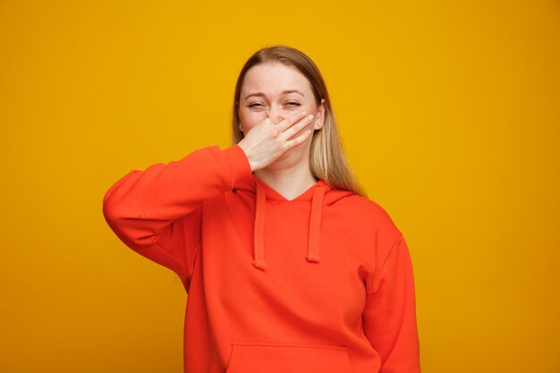 Mujer rubia joven disgustada haciendo gesto de mal olor