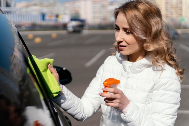 Mujer rubia limpiando su coche