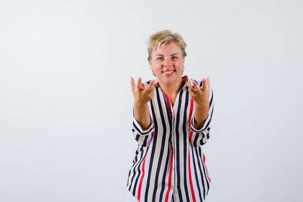 Mujer rubia madura en una camisa de rayas verticales