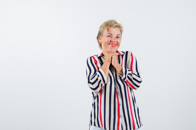 Mujer rubia madura en una camisa de rayas verticales