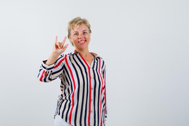 Mujer rubia madura en una camisa de rayas verticales