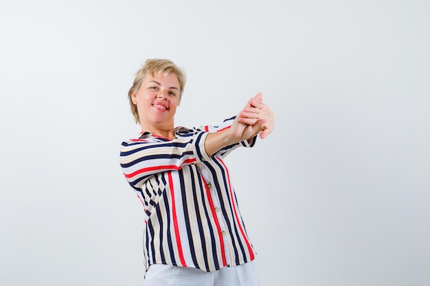 Mujer rubia madura en una camisa de rayas verticales