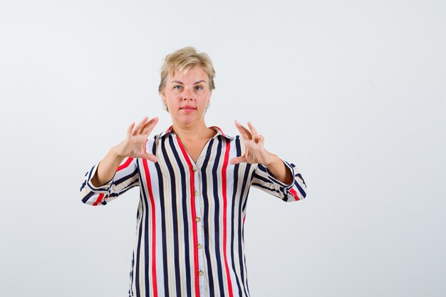 Mujer rubia madura en una camisa de rayas verticales