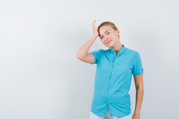 Mujer rubia manteniendo la mano en la cabeza aislada