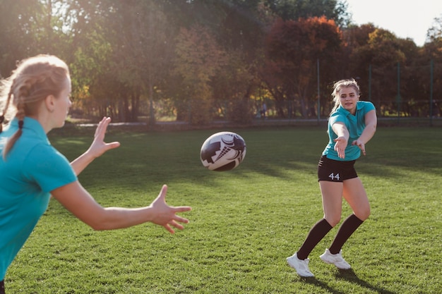 Foto gratuita mujer rubia pasando un balón de fútbol