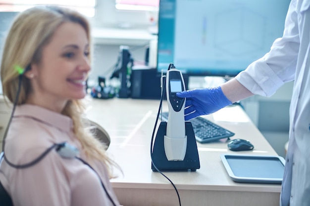 Mujer rubia de pelo largo con un control de audición en el hospital