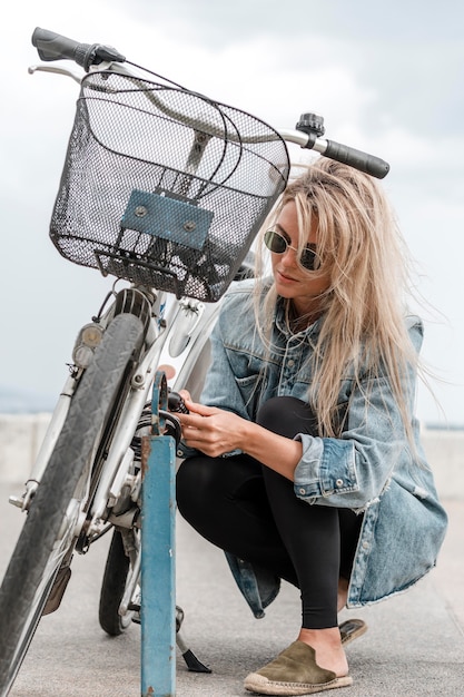 Mujer rubia poniendo un candado de bicicleta