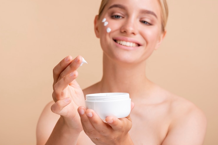 Foto gratuito mujer rubia de primer plano con crema para la cara y tarro