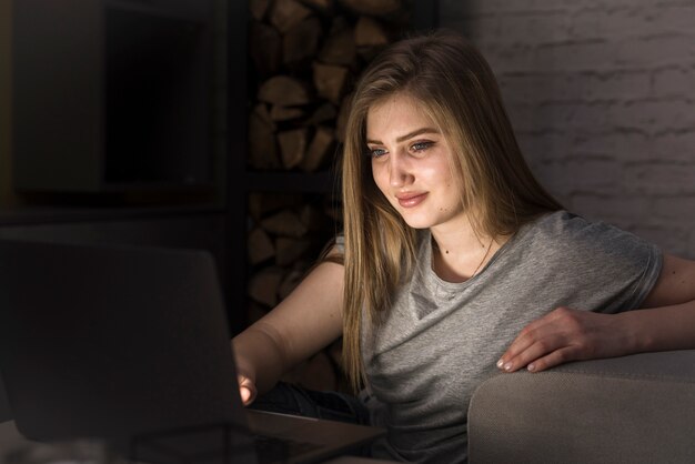Mujer rubia que mira en su computadora portátil