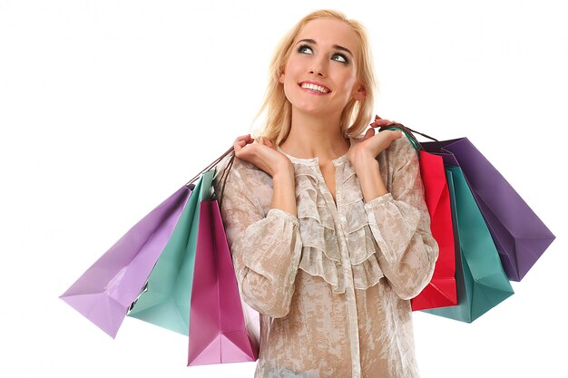 Mujer rubia que sostiene bolsos de compras