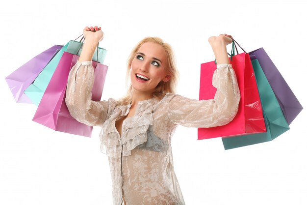 Mujer rubia que sostiene bolsos de compras