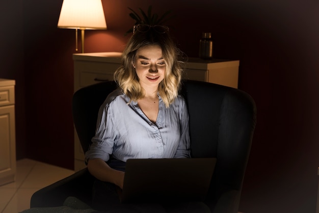 Mujer rubia que trabaja en la computadora portátil