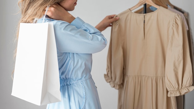 Mujer rubia revisando ropa nueva