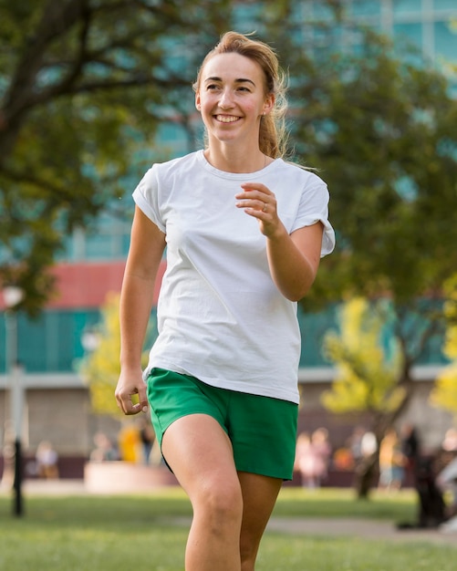 Mujer rubia en ropa deportiva corriendo