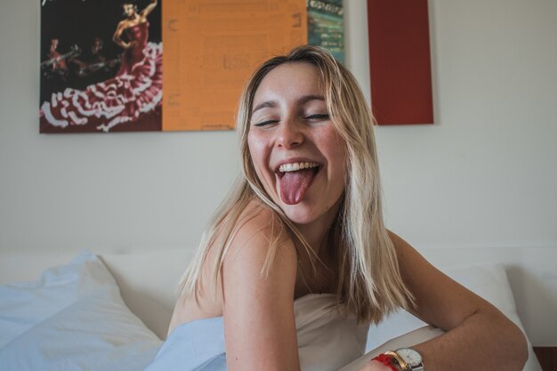 Mujer rubia sacando la lengua