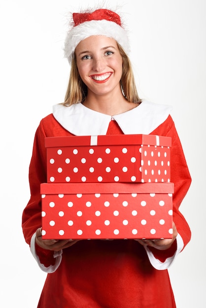 Mujer rubia en Santa Claus ropa sonriente con cajas de regalo.