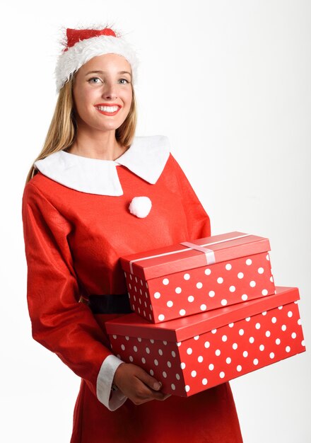 Mujer rubia en Santa Claus ropa sonriente con cajas de regalo.