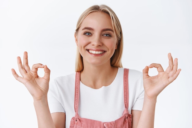 Foto gratuita la mujer rubia satisfecha de primer plano anima a un amigo a no darse por vencido como un resultado increíble, piensa que todo es excelente, muestra bien, está bien, no hay problema, gesto y sonriendo de acuerdo siendo solidario.