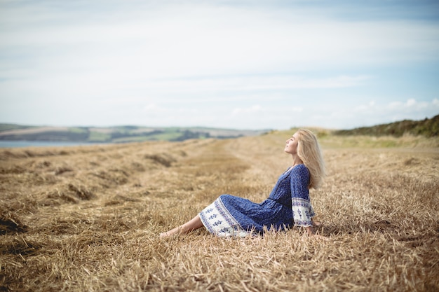 Mujer rubia sentada en el campo