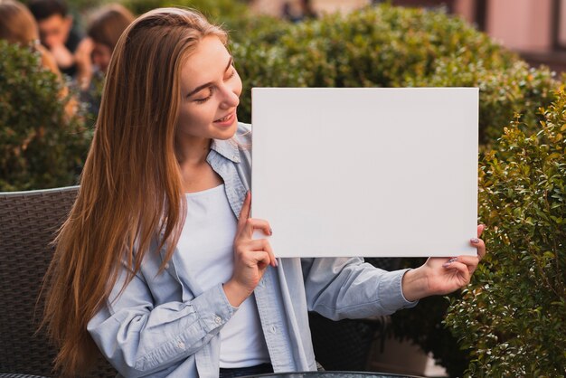 Foto gratuita mujer rubia sonriente con un cartel simulado