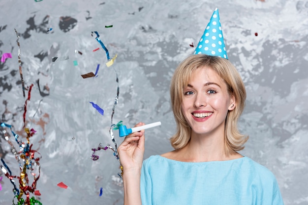 Mujer rubia sonriente con sombrero de fiesta