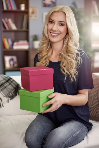 Mujer rubia sosteniendo cajas de colores