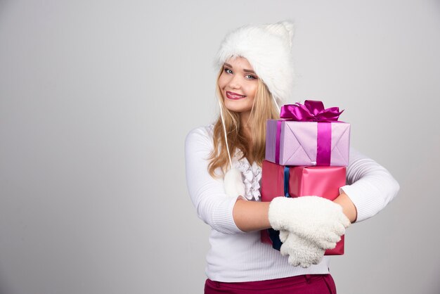 Mujer rubia sosteniendo regalos de vacaciones con fuerza.