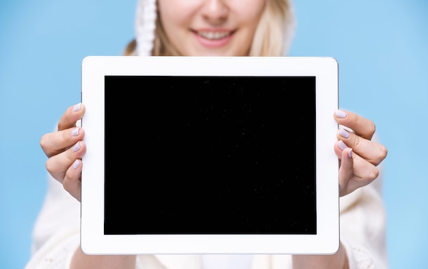 Mujer rubia sosteniendo una tableta con maqueta
