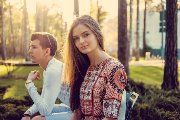 Mujer rubia y su novio posando en el parque de verano.