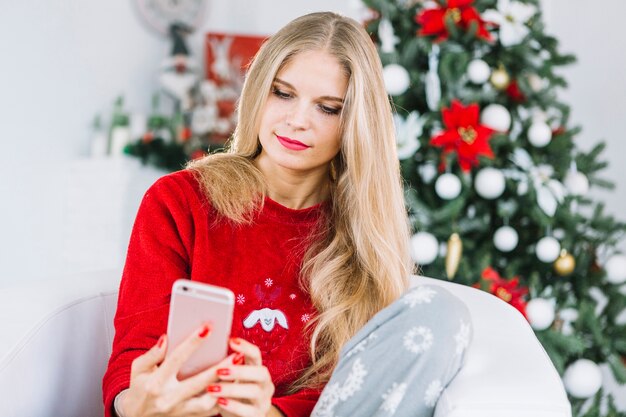 Mujer rubia en suéter tomando selfie