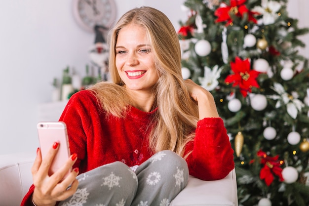 Mujer rubia en suéter tomando selfie