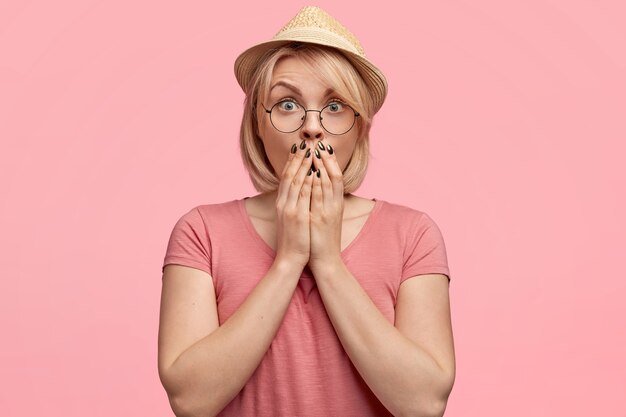 Mujer rubia vestida con camiseta rosa y sombrero