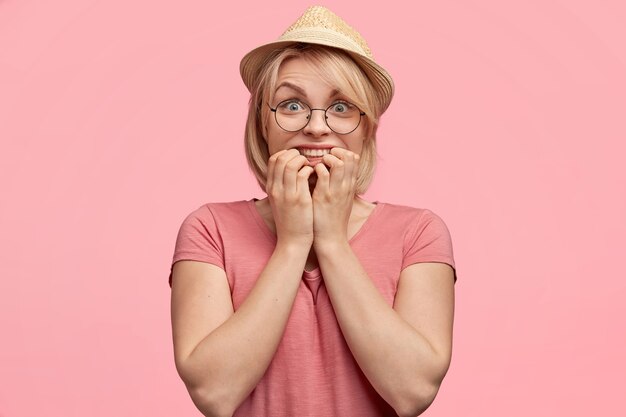 Mujer rubia vestida con camiseta rosa y sombrero