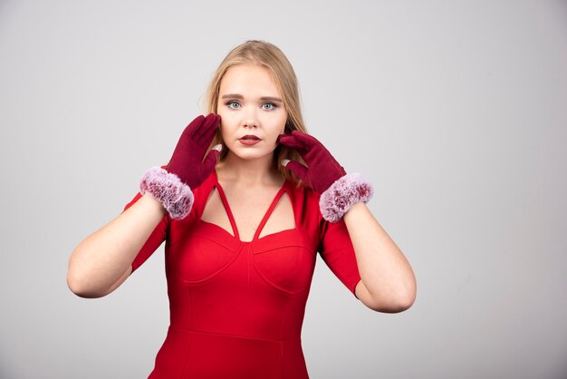 Mujer rubia en vestido de cóctel rojo mirando a la cámara.