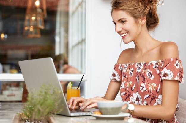 Mujer rubia en vestido floral en café