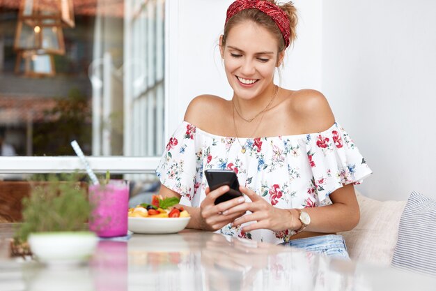 Mujer rubia en vestido floral en café