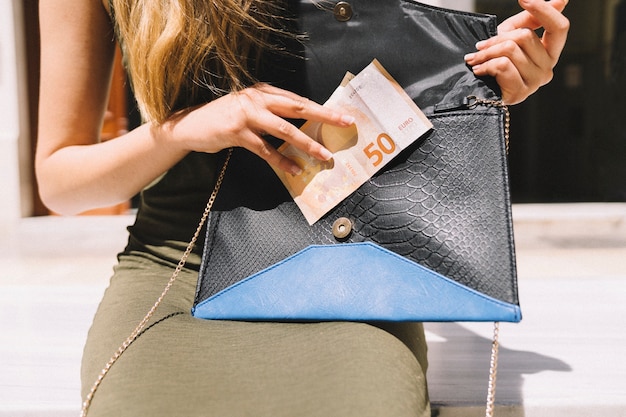 Mujer sacando dinero de su bolso