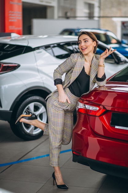 Mujer en una sala de exposición de coches soñando con un coche