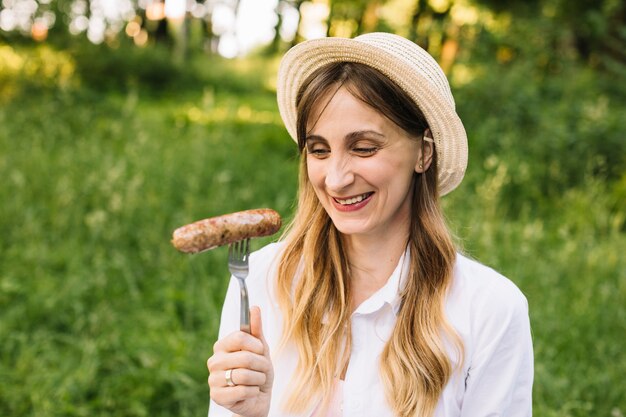 Mujer con una salchicha en la naturaleza