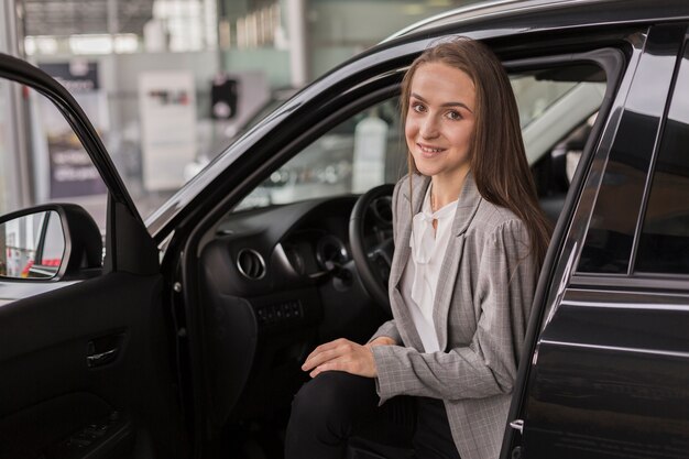 Mujer saliendo de un automóvil moderno