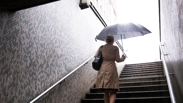 Mujer saliendo por la ciudad mientras llueve