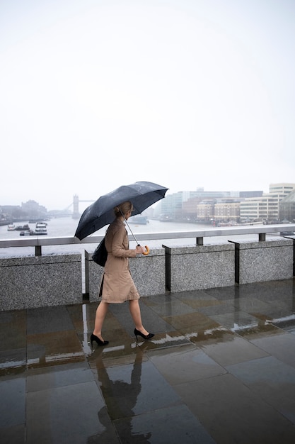 Foto gratuita mujer saliendo por la ciudad mientras llueve