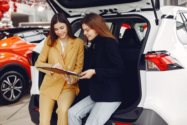 Mujer en un salón de autos hablando con el asistente