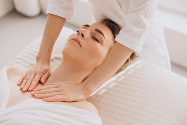 Mujer en un salón de belleza con masaje facial y de cuello