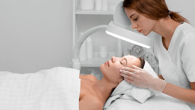 Foto gratuita mujer en salón de belleza para tratamiento facial