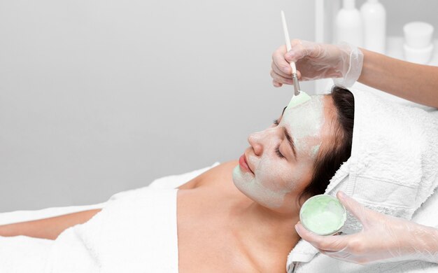 Mujer en salón de belleza para tratamiento facial