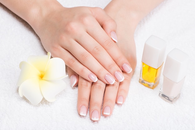 Mujer en un salón de uñas recibiendo manicura por una esteticista. Concepto de tratamiento de belleza.