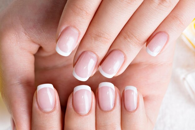 Mujer en un salón de uñas recibiendo manicura por una esteticista. Concepto de tratamiento de belleza.