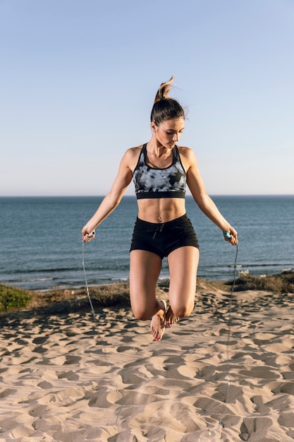 Mujer saltando a la cuerda en la playa