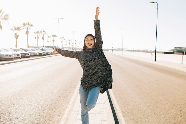 Mujer saltando en medio de la calle